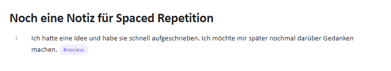 Ein Screenshot zeigt eine Notiz mit dem Titel "Noch eine Notiz für Spaced Repetition". Unter dem Titel steht der Text: "Ich hatte eine Idee und habe sie schnell aufgeschrieben. Ich möchte mir später nochmal darüber Gedanken machen." Am Ende des Satzes befindet sich ein hervorgehobenes Schlagwort "#review" in einer lila Blase. Links neben dem Text ist die Zahl "1" zu sehen, die die Zeilennummer anzeigt.