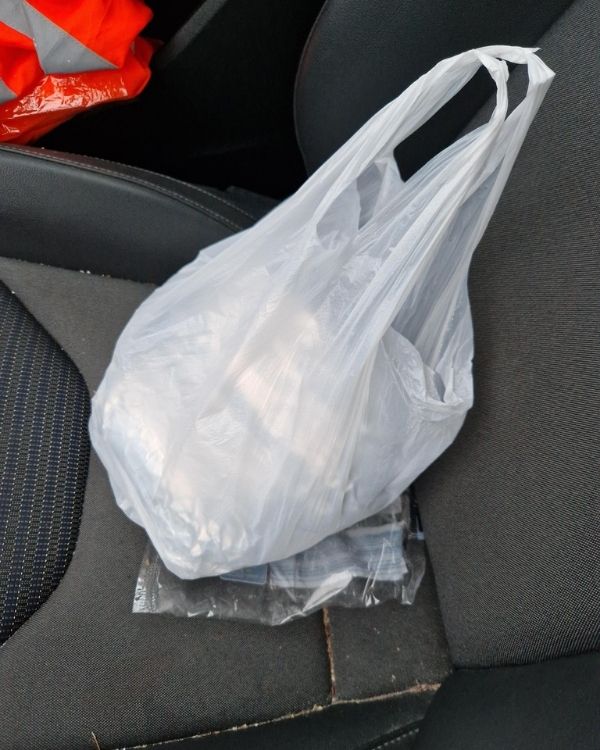 Plastiktüte mit Döner auf dem Autositz.
